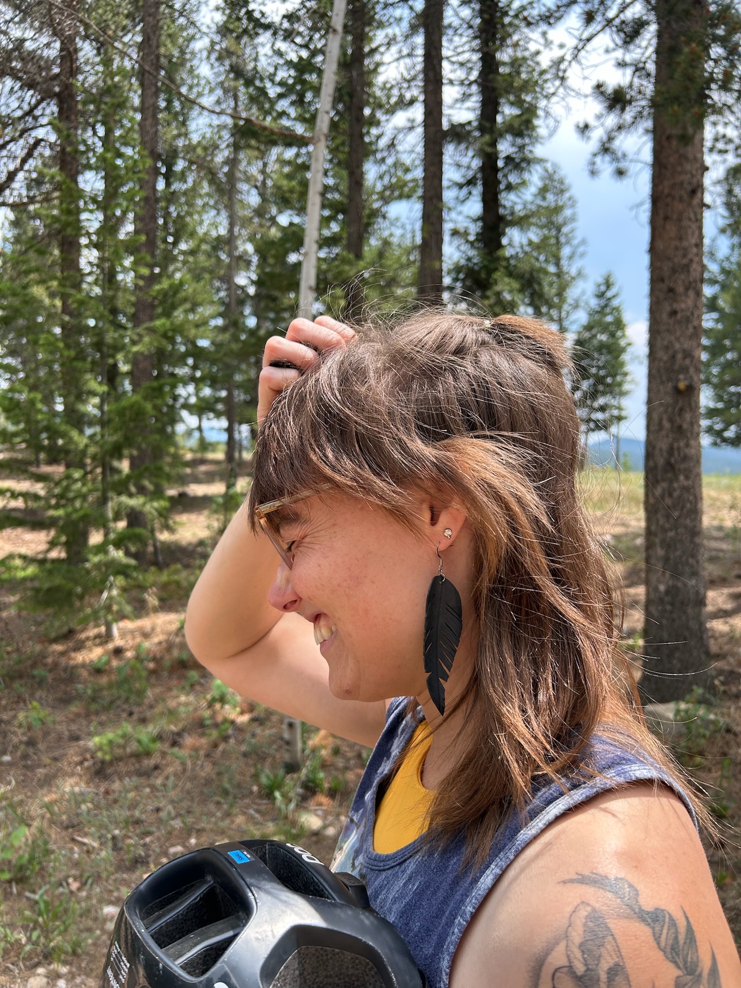Showing off a feather earring cut from a bike tube