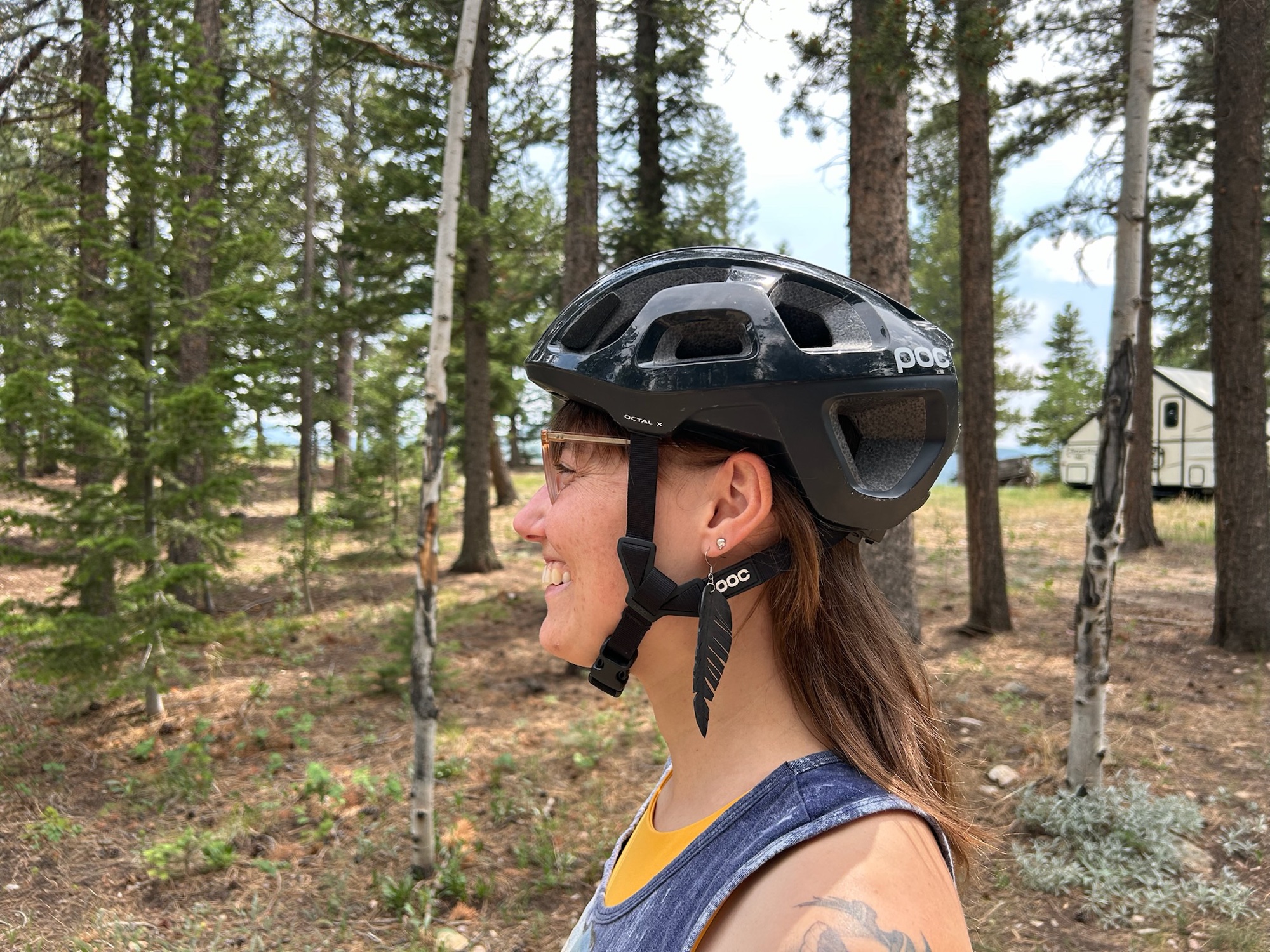Bike-tube feather earring paired with a helmet — ready to ride