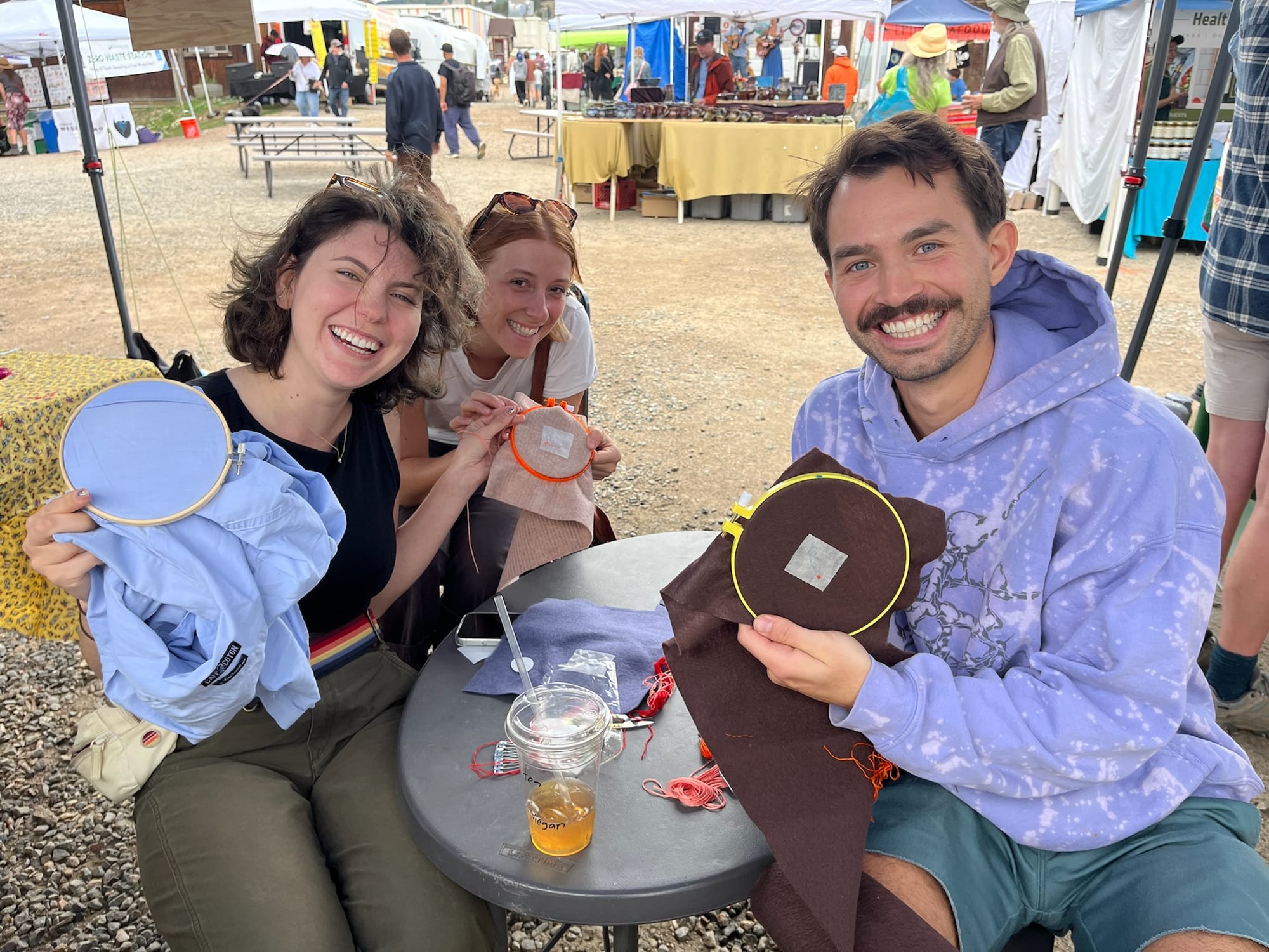 Three makers showing off the hoops they started at the market